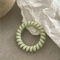 Nahaufnahme von pastellgrünem Spiral-Haargummi mit hoher Elastizität und Glanz - Hellgrün