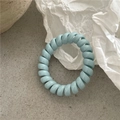 Makroaufnahme der hellblauen Spiral-Haargummis mit glatter und elastischer Textur - Hellblau