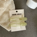 Detail of light green jelly translucent hair clips on a handmade eco-friendly paper card - Green