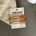 Detail of amber translucent hair clips in a 2-piece set on handmade card packaging - Brown