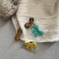Close-up of colorful resin hair clips with bow and star shapes on textured stones - Bow/Star Style (F7.2 Type A 1 Duckbill Clip)