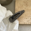 Gros plan détaillé d'une pince à cheveux goutte avec strass gris sur un support en pierre - Noir