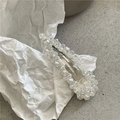 Vue détaillée de la pince à cheveux en perles de cristal sur une surface en pierre - Transparent Larme