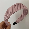 Détail d'un serre-tête en satin plissé rose avec texture de tissu lisse et design large - Rose racine de lotus