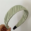 Gros plan sur le serre-tête en satin plissé vert sauge montrant les détails du tissu - Vert Pâle