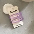 Detail of two purple translucent teardrop hair clips on display card with stone decor - Waterdrop Duckbill Clip / Purple