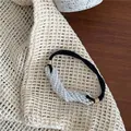 Detailed view of pearl beaded elastic hair tie with gold clasps on textured background - White Artificial Pearl Hair Tie