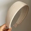 Detail of soft cream beige knitted fabric headband with non-slip lining and thick texture - White