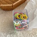 Close-up of colorful seamless elastic hair ties in a cute cartoon branded acrylic box - Orange Colorful