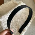 Detail view of the stitching on a minimalist black faux leather headband with anti-slip tips - Black