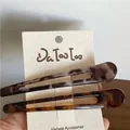 Dettaglio di due fermagli per capelli con stampa leopardata su carta bianca - Stile leopardato a contrasto cavo lungo