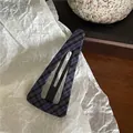 Close-up of a navy blue plaid fabric covered triangular BB hair clip on a paper backdrop - Large Hollow Triangle Style (D1.1) / Navy Plaid