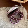 Detail of four knit hair ties with plaid, dots, and stripes on a beige woven mat - Pink Coffee Style