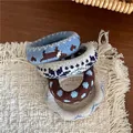 Detail of four knit hair ties with patterns on a woven mat and dark wood table - Blue Coffee Style