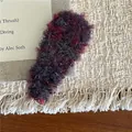 Primer plano de pinza para el pelo de felpa multicolor sobre fondo de tela beige suave - Mezcla Roja (G6.3)