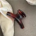 Close-up of translucent amber resin hair claw clip with elegant tortoiseshell texture - Crescent Hanger Claw / Red Tortoiseshell