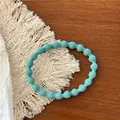 Detail showing the ribbed texture and tiffany blue color of a bubble style elastic hair tie - Light Blue-Green