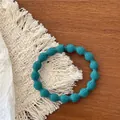 Detailed view of Tiffany blue elastic hair tie with textured spherical bubble design - Teal Blue