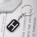 Close-up of hip hop style metal keychain with rhinestone letter H charm on magazine - Letter H