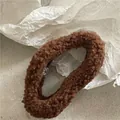 Detalle de un coletero de felpa marrón oscuro con textura suave de lana de cordero rizada - Café oscuro