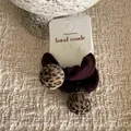 Detail van haarelastiekjes met luipaardprint ballen op een handgemaakte kaart - Bruin