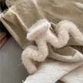 Détail d'une pince à cheveux beige en peluche ondulée avec une texture laineuse douce - Blanc Cassé