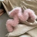 Vue détaillée d'une pince à cheveux en peluche rose avec design en M sur lin doux - Rose