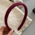 Detailed close-up of burgundy wool-wrapped headband with soft fleece texture and tag - Burgundy