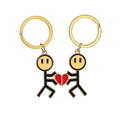 Dettaglio di portachiavi coppia con omini magnetici e pezzi di puzzle a cuore rosso - Oro