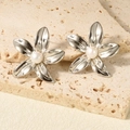 Vista dettagliata di orecchini a lobo a fiore con petali d'argento lucido e perla centrale - Stile Argento