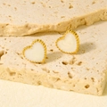Detailweergave van hartvormige gouden oorknopjes met emaille en fijne kralenrand - Goud Wit Stijl (D515-G-W)