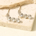Dettaglio di orecchini a perno in argento con tre strass scintillanti curvati - Base Argento Strass Bianco (D544-S-W)