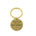 Primer plano de llavero dorado con texto motivacional grabado para mujeres - Inspirational AWESOME Style / Dorado