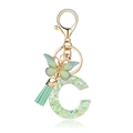 Portachiavi lettera C in resina verde con farfalla e paillettes su sfondo bianco - Farfalla Verde C