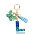 Close-up of blue sequin resin letter L keychain with butterfly and tassel detail - Letter L