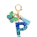Detail of resin letter P keychain with blue sequins, butterfly charm and blue tassel - Letter P