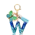 Close-up of letter W keychain with blue heart sequins, butterfly charm, and blue tassel - Letter W