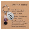 Detail of natural gemstone beads and engraved stainless steel tag on card packaging - Anxiety Relief