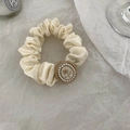 Dettaglio dell'elastico in raso con bottone a rosa vintage e bordo di perle crema - Beige