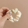 Detalle de coletero de satén crema con un colgante de corazón dorado texturizado - Beige