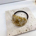 Elastic hair tie with amber marble texture acetate charm on stone surface - Khaki Pattern