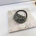 Elastic hair tie with a black and white speckled resin accent on a stone base - Black White Dots