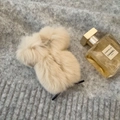 Close-up of soft creamy white plush hair claw clip on a grey knitted texture background - Champagne