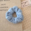 Light blue faux shearling hair scrunchie with fluffy wool texture on linen background - Blue