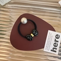 Dettaglio di elastico per capelli nero con fiocco in resina e grande perla bianca - Nero