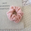 Pink plush faux shearling hair scrunchie shown on a warm aesthetic background - Light Pink