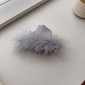 Detail view of the soft grey feather hair claw clip with luxurious silk texture and fluffy plumes - Gray