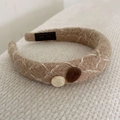Detail van beige gebreide hoofdband met witte kruissteken en decoratieve knopen - Licht Koffiebruin (C-1247-4)