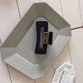 Dettaglio di un mollettone nero in acrilico con logo dorato su vassoio in ceramica - Stile Piastra Bianca (B-2653-1)