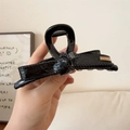 Elegante pinza per capelli con fiocco in pelle nera e targhetta in metallo dorato - Nero